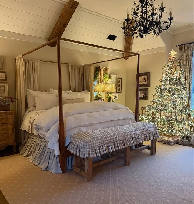 Four poster bed with white linens, gingham bench and flocked Christmas tree