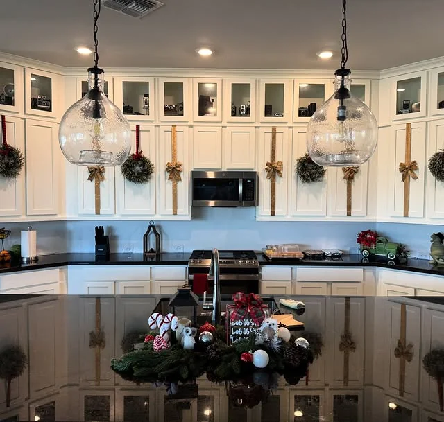 Glass front kitchen cabinets decorated with gold Christmas bows