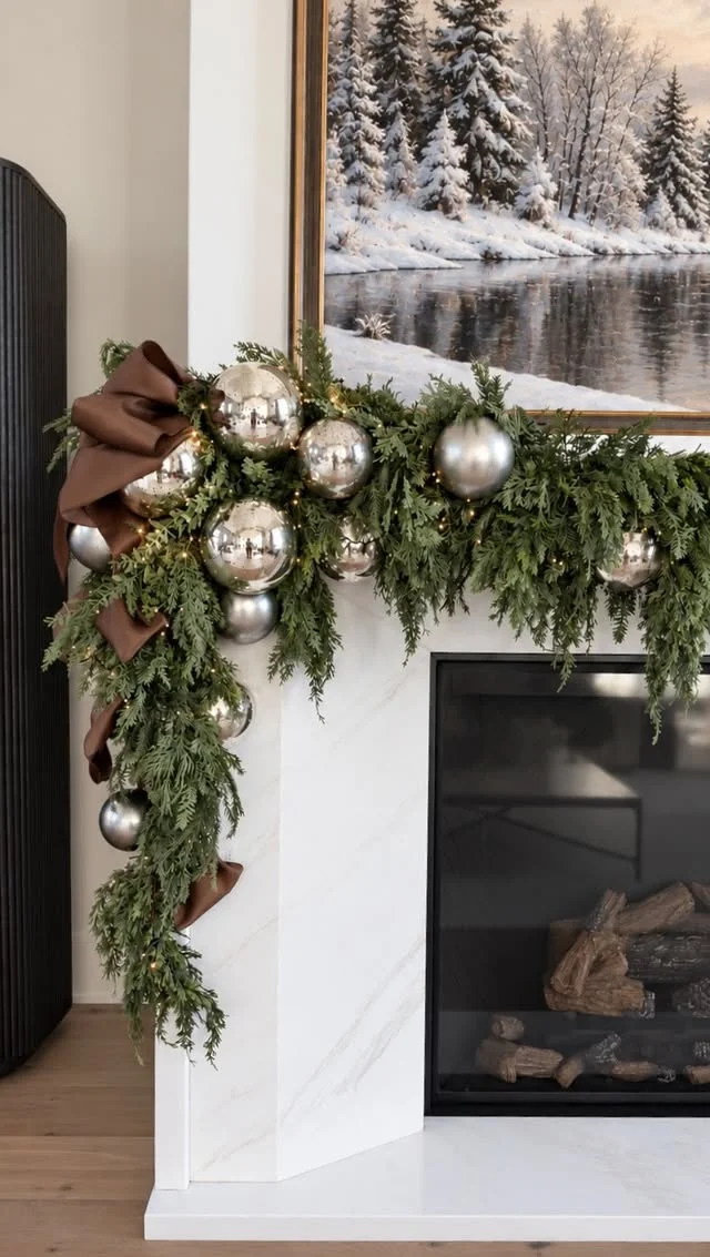 White mantel with brown velvet bows and lush green garland