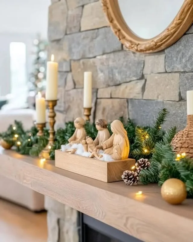 Wooden mantel with brass candlesticks, greenery, and nativity figures
