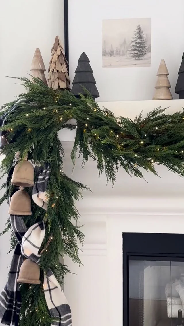 Green garland with plaid ribbon and brass bells, close-up