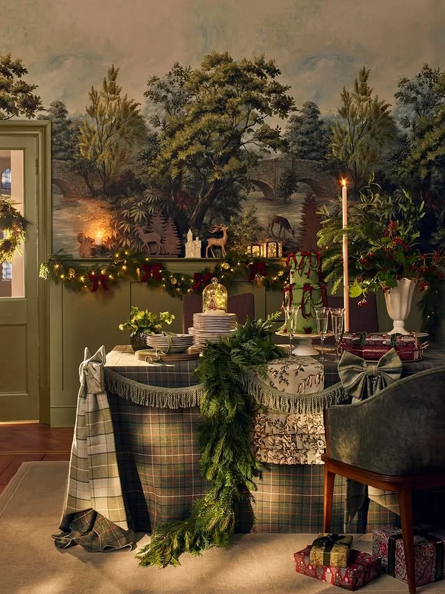Farmhouse Christmas table with plaid tablecloth, garland, and tall candles