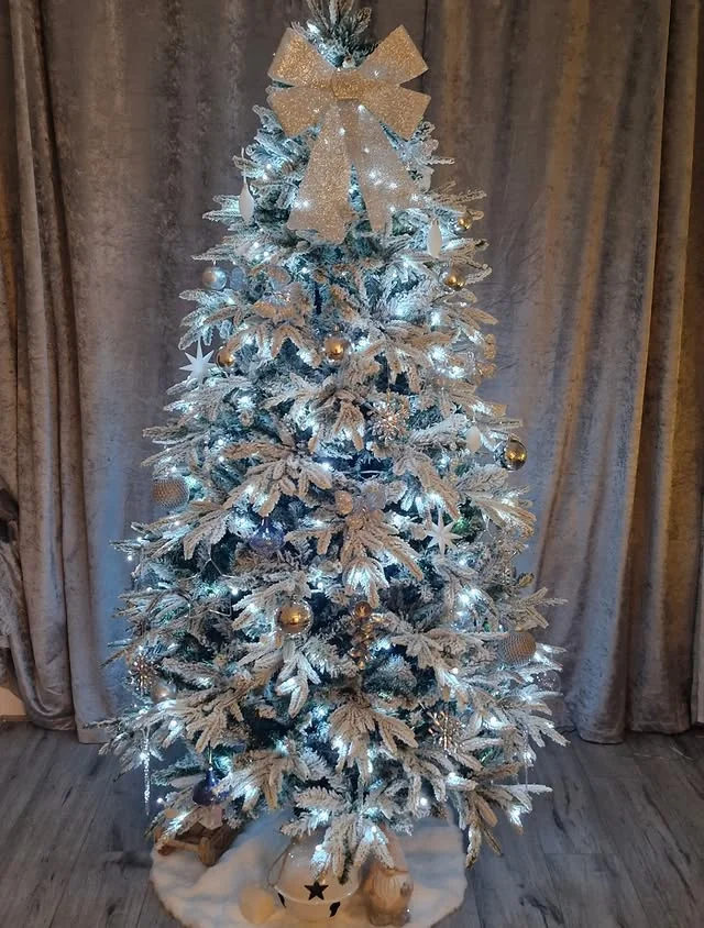 Flocked christmas tree with silver and gold ornaments and white fairy lights