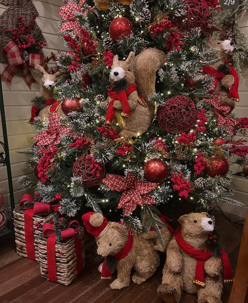 Flocked christmas tree with red glitter baubles, pinecones and checkered bows