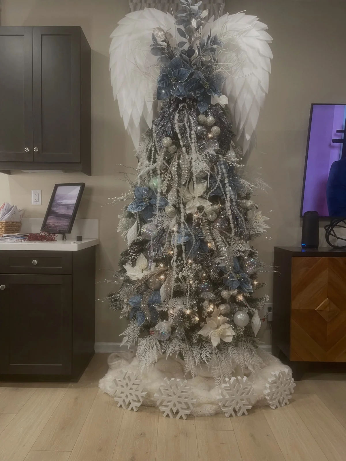 Christmas tree in winter blue palette with silver glitter and white poinsettias
