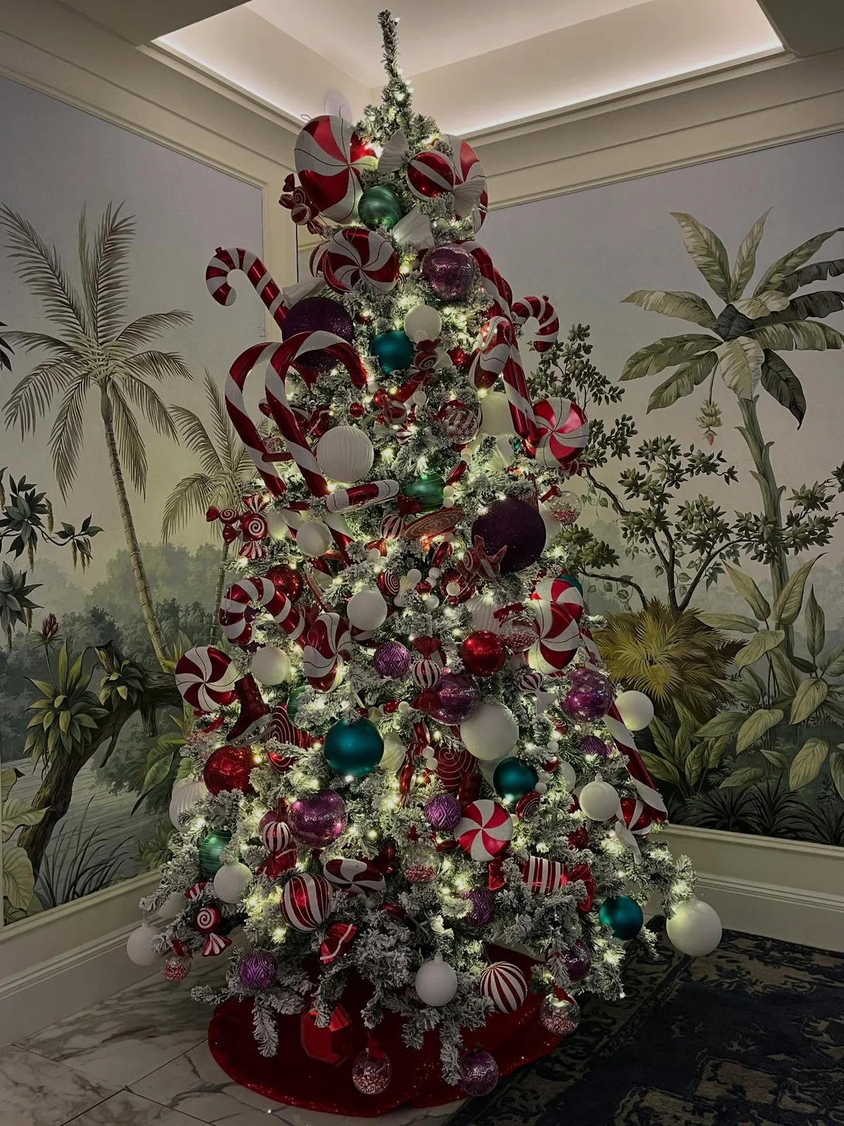 Flocked christmas tree with oversized candy canes and peppermint ornaments