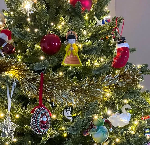 Close up of clustered christmas ornaments with red baubles and gold tinsel
