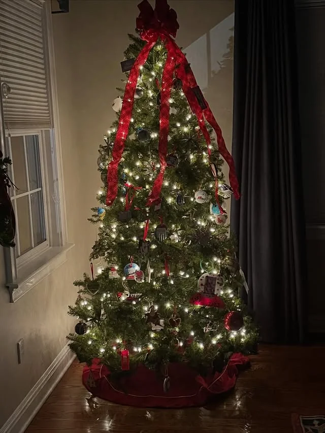 Christmas tree with large red bow and cascading red plaid ribbon