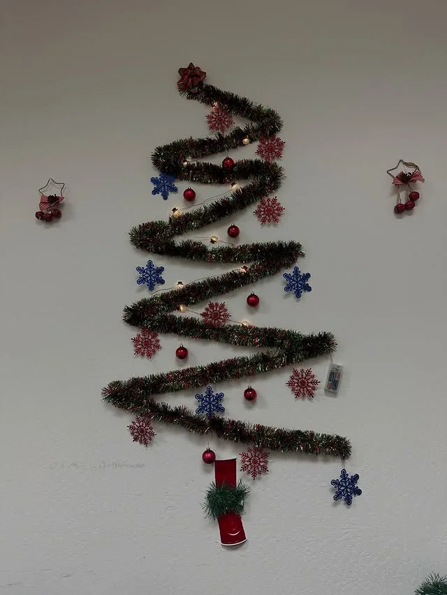 Spiral tinsel Christmas tree decoration affixed to a wall