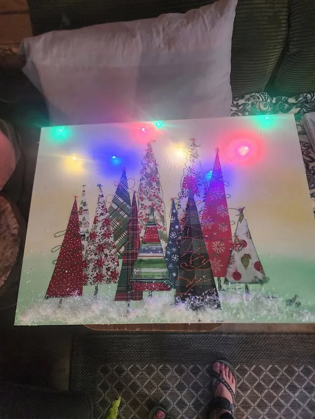 Canvas artwork of patterned paper Christmas trees with fairy lights