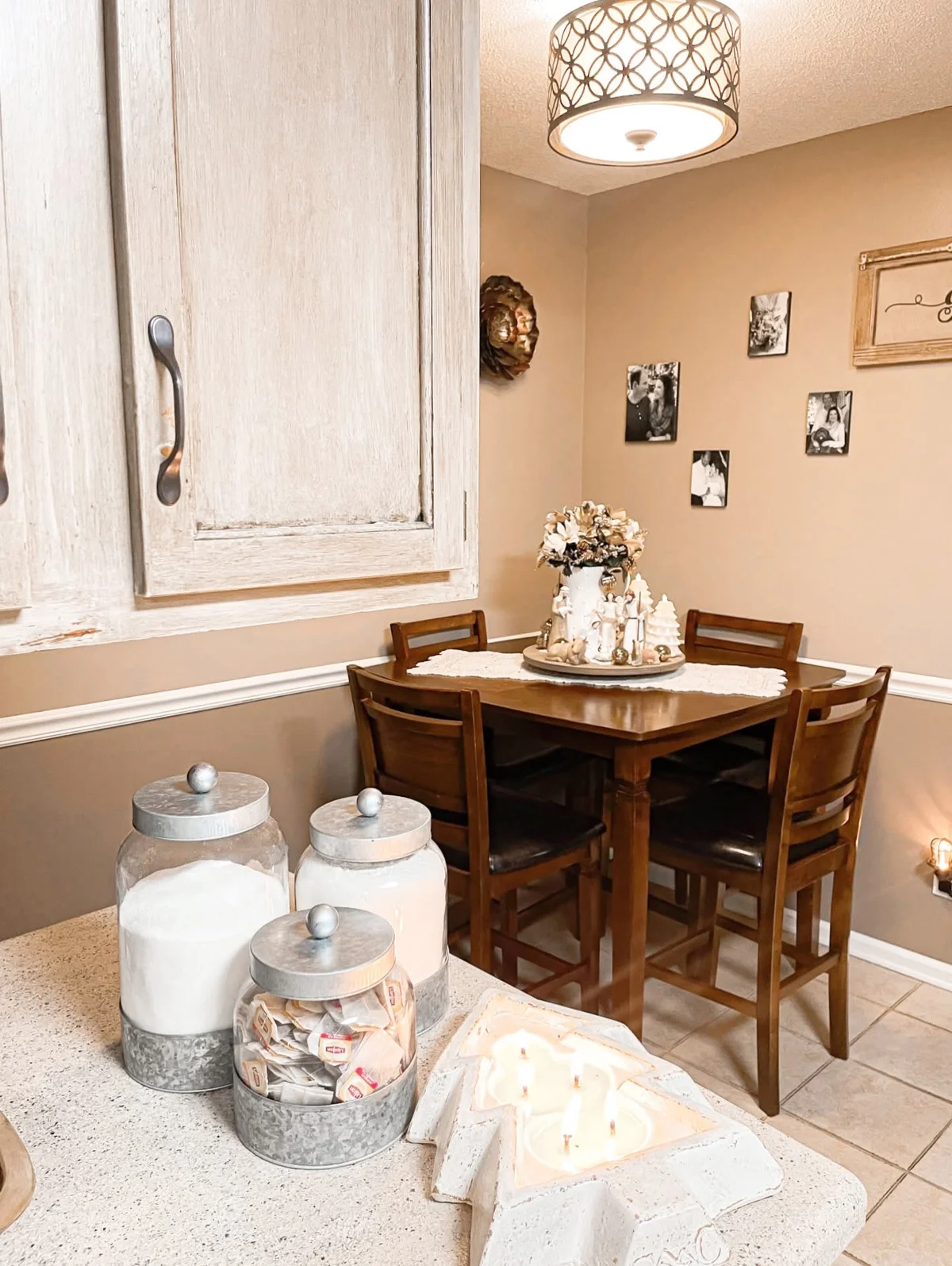 Galvanized canisters and a white Christmas candle arranged on a farmhouse counter