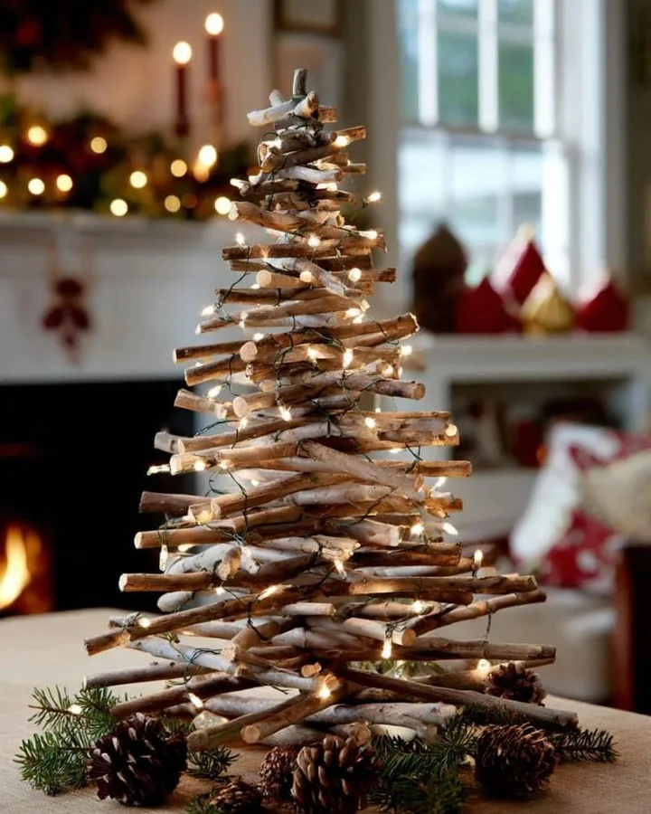 Small Christmas tree built from stacked twigs and wrapped in fairy lights