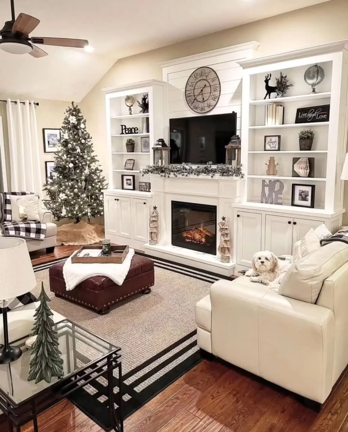 White shiplap living room with a tall Christmas tree and buffalo check chair