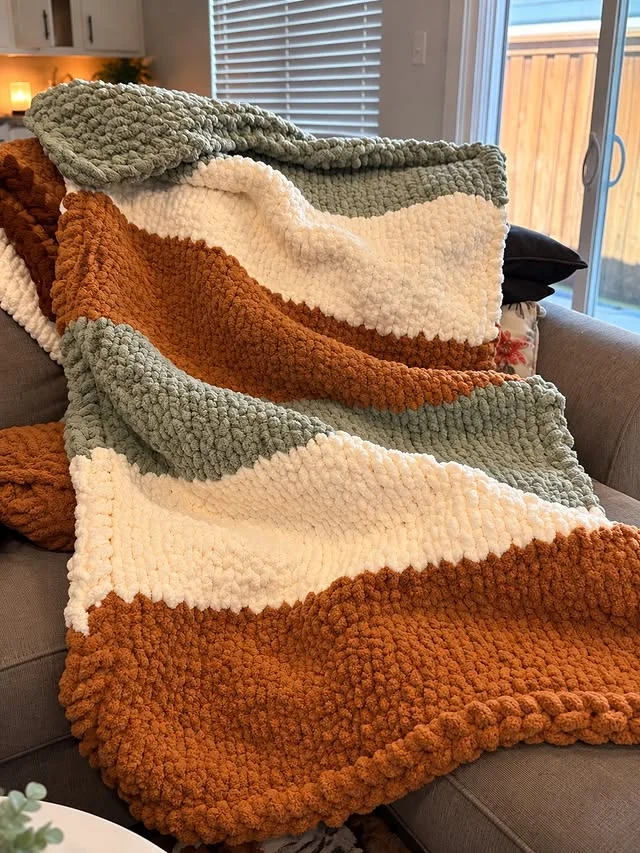 Chunky knit throw blanket draped on a couch