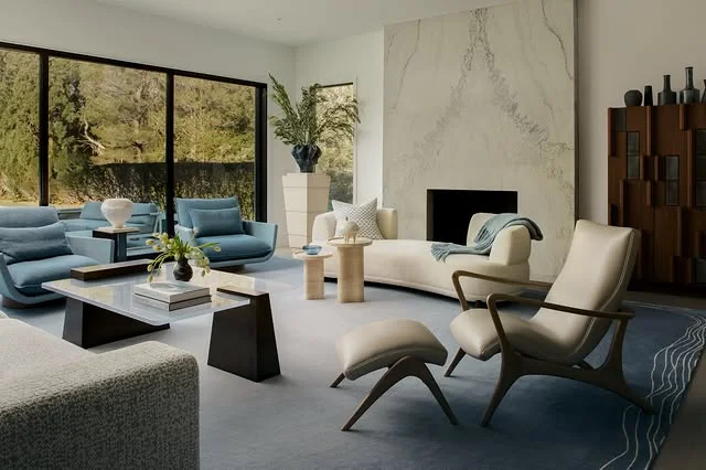 Bright modern living room with blue sofa and marble fireplace