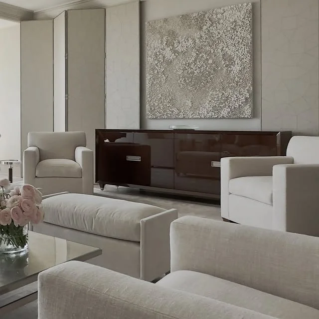 Neutral modern sitting room with cream chairs and abstract art
