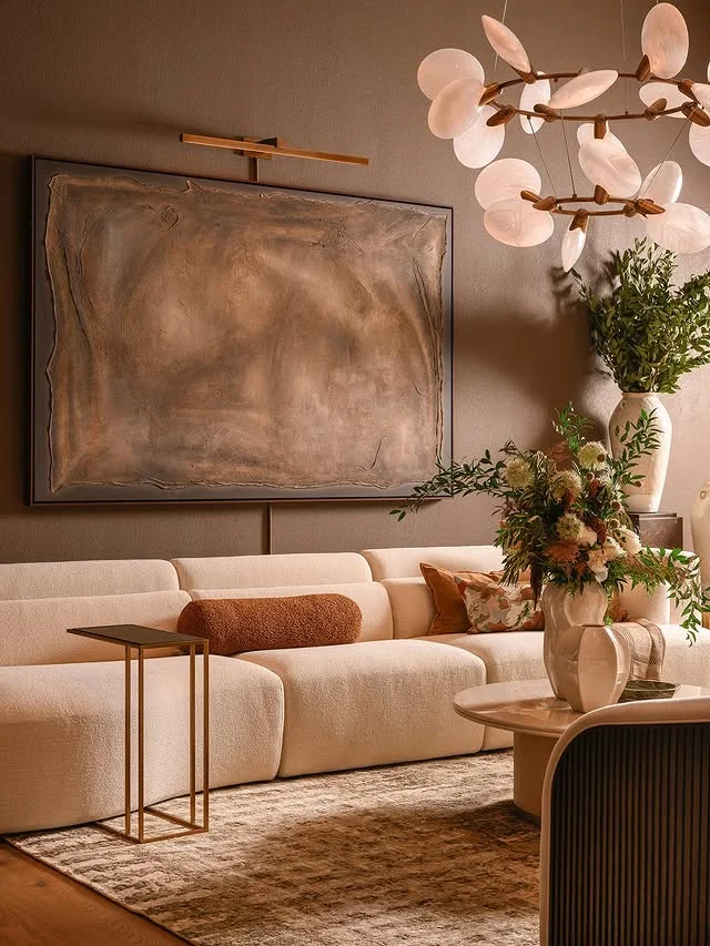 Warm modern living room with cream sofa and sculptural chandelier