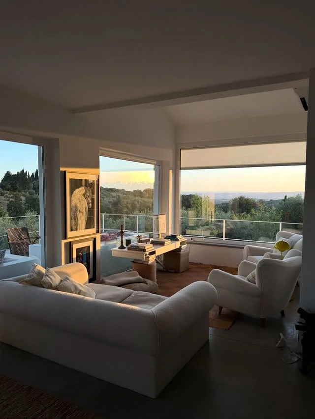 Bright modern living room with white sofas and large windows