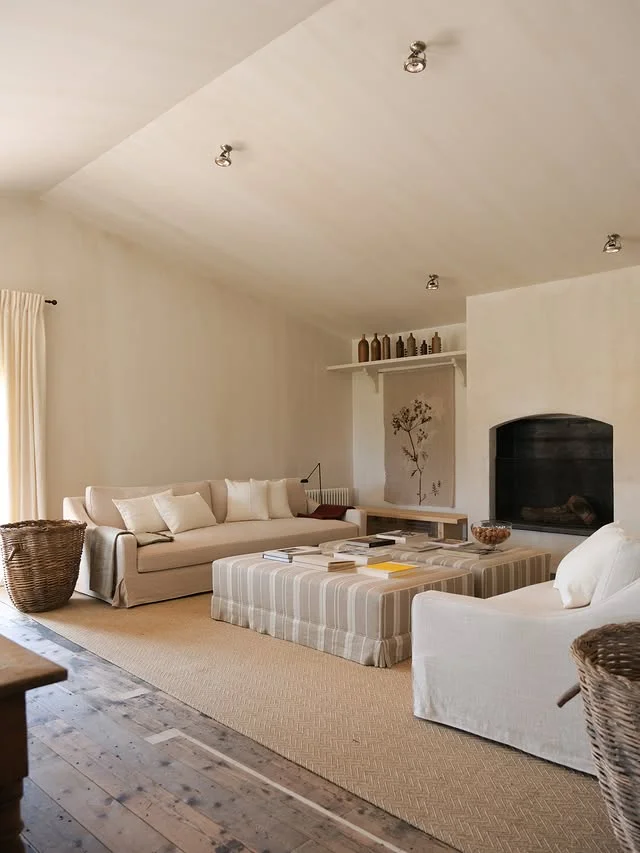 Neutral minimalist living room with slipcovered sofas and fireplace