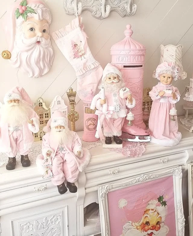 White cabinet styled with pink Santa figurines, a pink postbox and a pink stocking