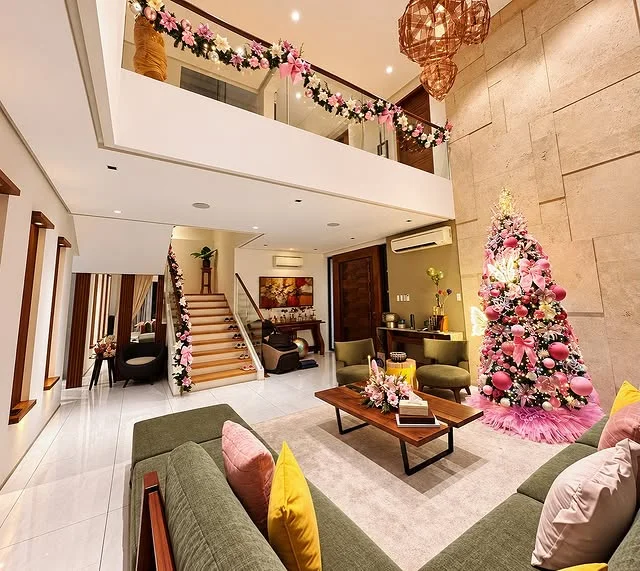 Luxurious living room decorated for Christmas with a pink and gold tree and pink accents