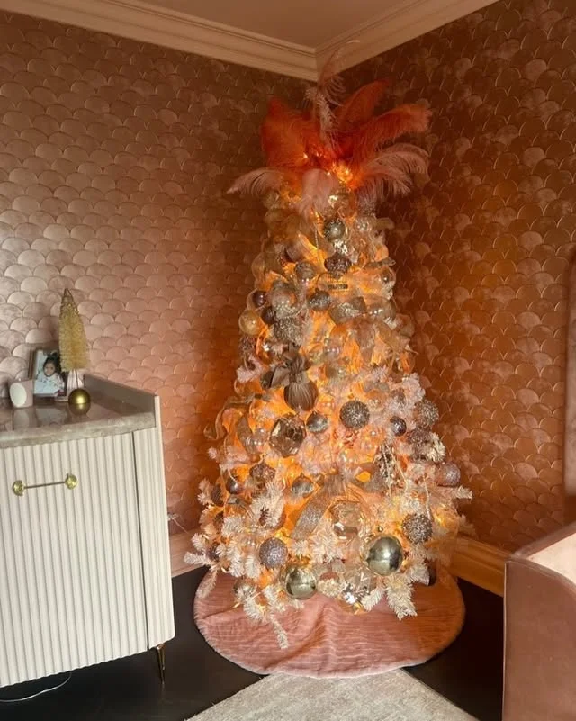 White and champagne Christmas tree with a blush feather topper and metallic ornaments